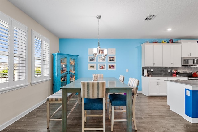 dining room featuring dark wood-type flooring and a textured ceiling