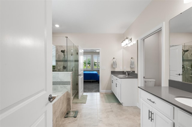 bathroom featuring vanity, tile patterned flooring, toilet, and a shower with door