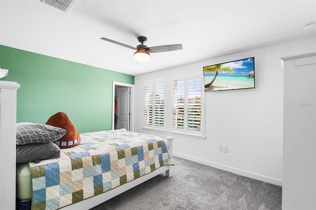 carpeted bedroom featuring ceiling fan and a textured ceiling