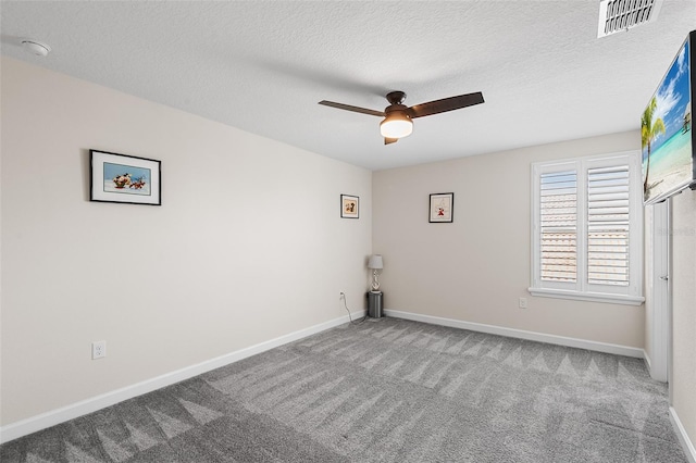 empty room with ceiling fan, carpet floors, and a textured ceiling