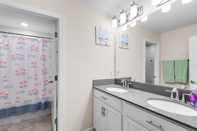 bathroom featuring tile patterned floors, vanity, curtained shower, and a textured ceiling