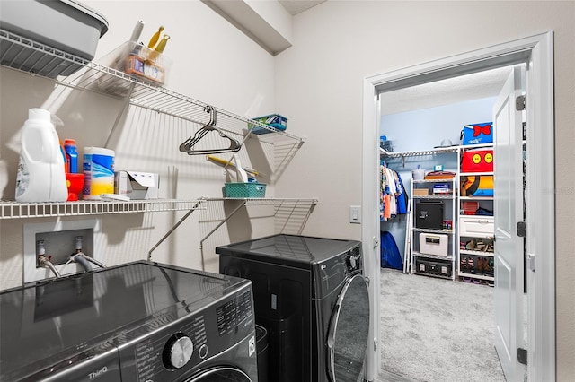 clothes washing area featuring separate washer and dryer and carpet flooring