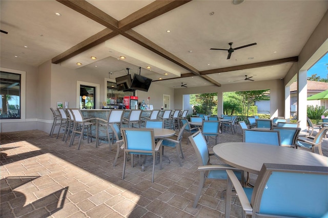 view of patio / terrace with ceiling fan and a bar