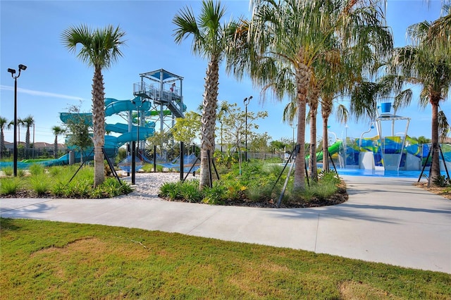 view of basketball court featuring a playground and a yard