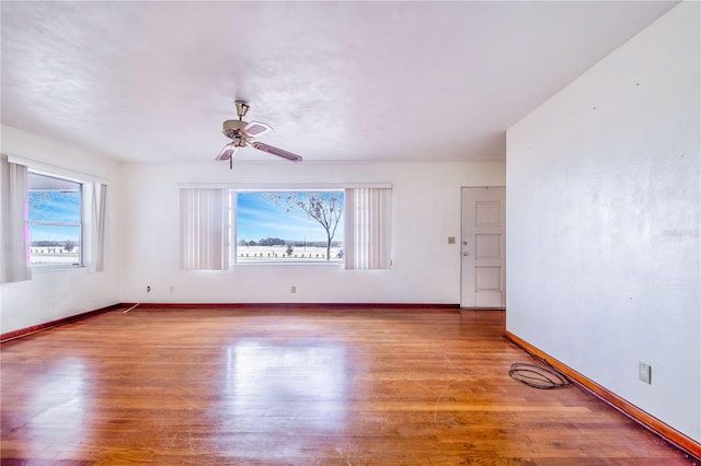 unfurnished room featuring hardwood / wood-style floors, plenty of natural light, and ceiling fan