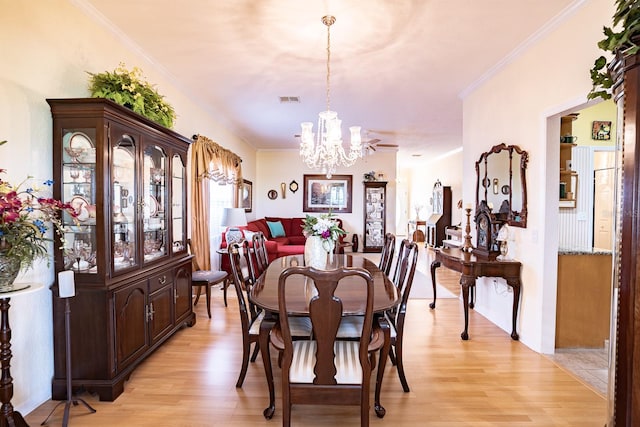 dining area featuring light hardwood / wood-style flooring, a notable chandelier, and ornamental molding