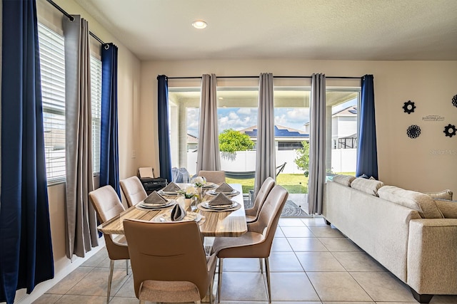 dining space featuring a textured ceiling, plenty of natural light, and light tile patterned floors