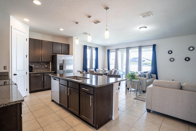 kitchen with pendant lighting, dark brown cabinets, appliances with stainless steel finishes, and sink