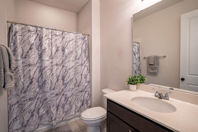 bathroom with tile patterned floors, walk in shower, vanity, and toilet