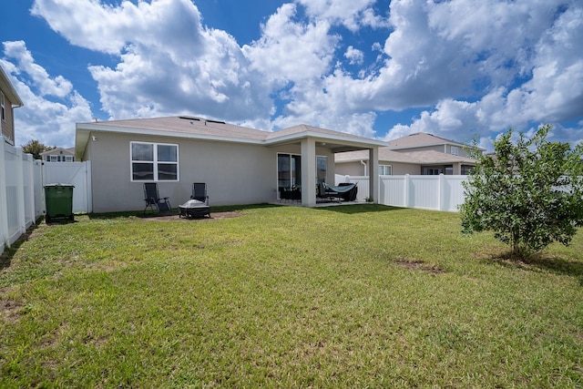 rear view of property featuring a yard and a patio area