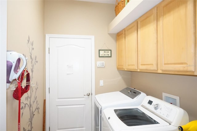 washroom with cabinets and independent washer and dryer