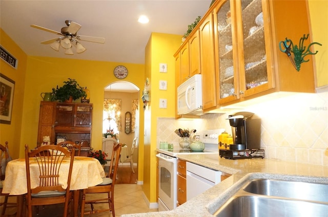 kitchen featuring light tile patterned flooring, ceiling fan, white appliances, and decorative backsplash