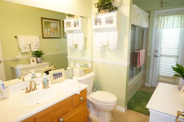 full bathroom featuring vanity, bath / shower combo with glass door, tile patterned floors, and toilet