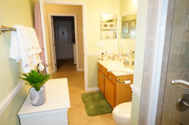 bathroom featuring tile patterned flooring, vanity, tiled shower, and toilet