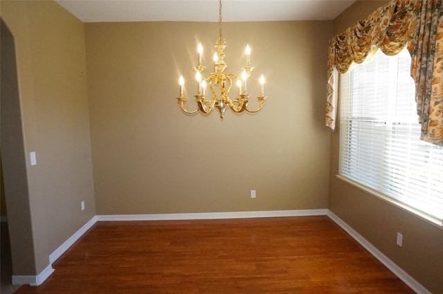 unfurnished dining area featuring wood-type flooring and a notable chandelier