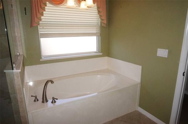 bathroom with a tub to relax in and tile patterned floors