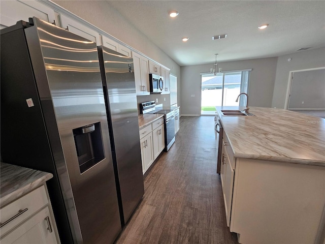 kitchen featuring a kitchen island with sink, sink, white cabinetry, stainless steel appliances, and dark hardwood / wood-style flooring