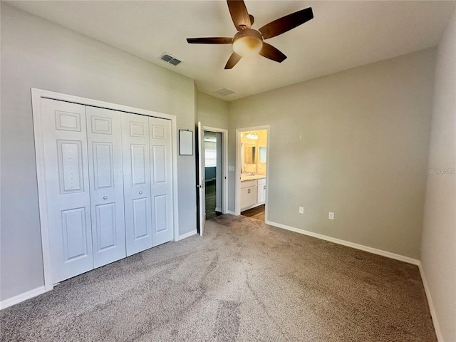 unfurnished bedroom with ceiling fan, ensuite bathroom, a closet, and carpet flooring