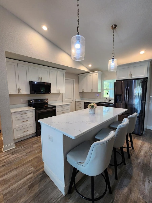 kitchen with a center island, electric range, decorative light fixtures, fridge with ice dispenser, and white cabinets