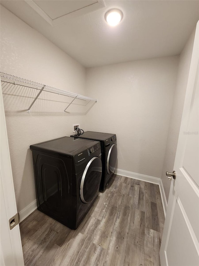 washroom featuring washing machine and clothes dryer and hardwood / wood-style floors