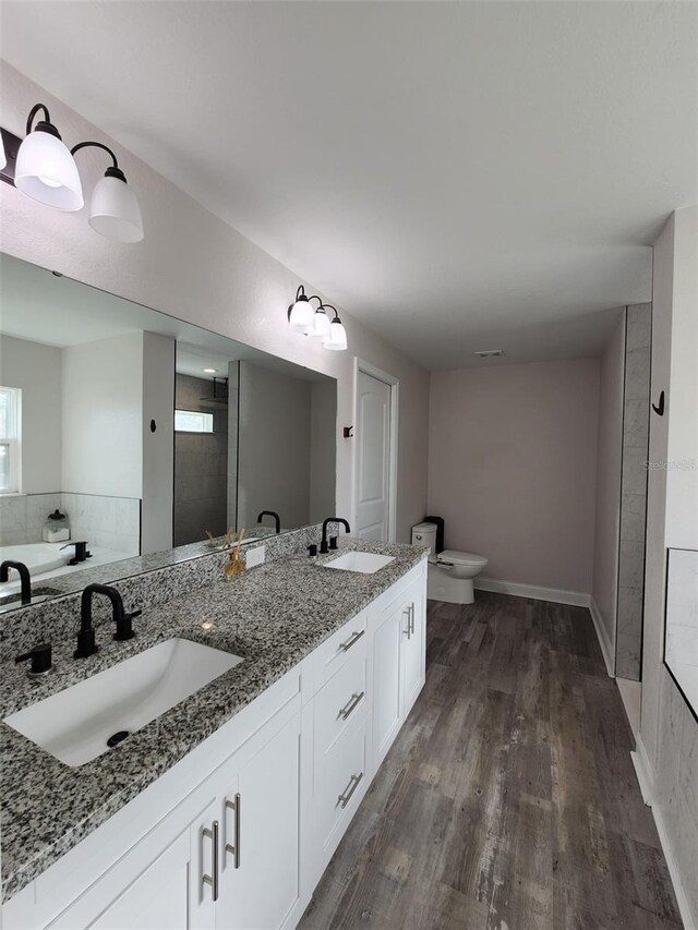 bathroom featuring vanity, toilet, hardwood / wood-style flooring, and walk in shower