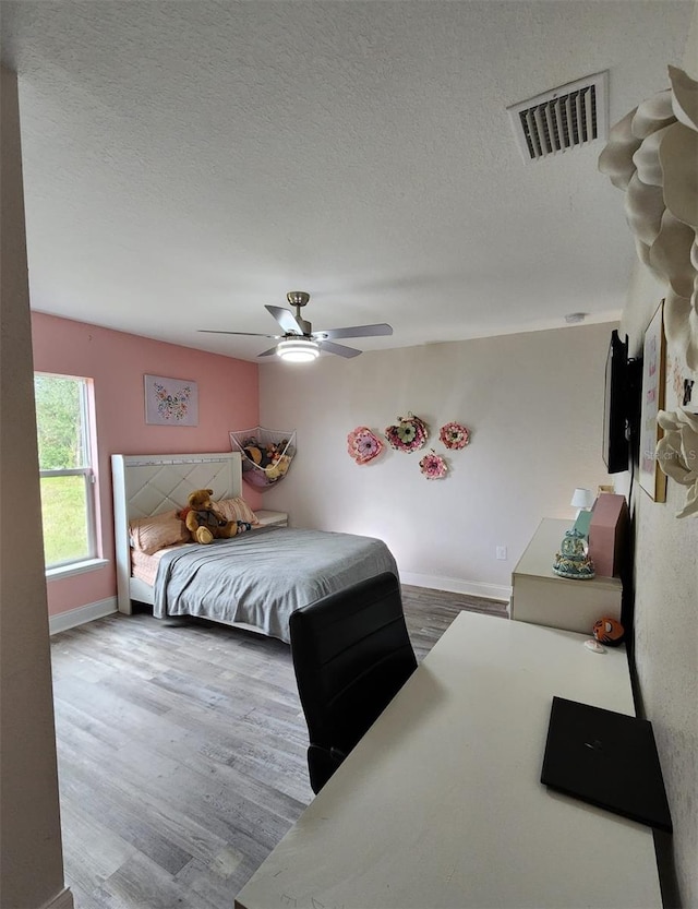 bedroom featuring a textured ceiling, wood-type flooring, and ceiling fan