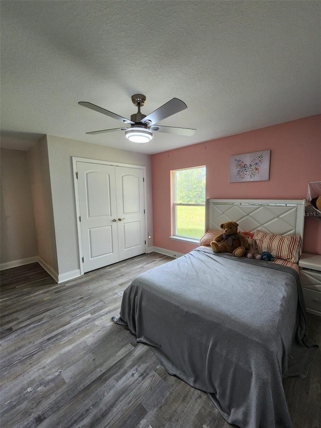 bedroom featuring a closet, a textured ceiling, hardwood / wood-style flooring, and ceiling fan