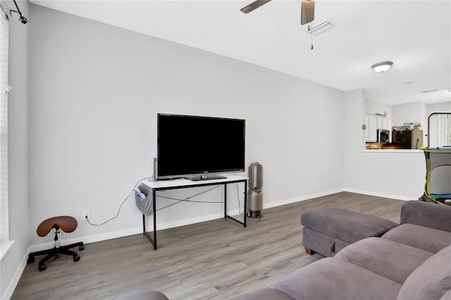 living room with wood-type flooring and ceiling fan