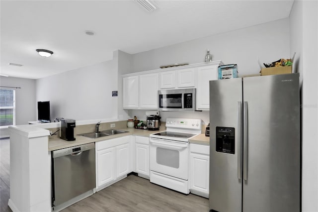 kitchen with white cabinets, sink, kitchen peninsula, stainless steel appliances, and light hardwood / wood-style floors