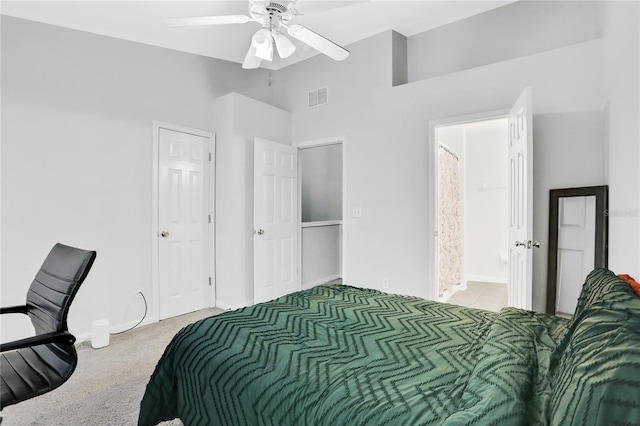 carpeted bedroom with a high ceiling, connected bathroom, and ceiling fan