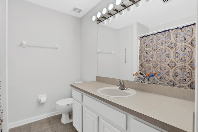 bathroom with tile patterned flooring, vanity, and toilet