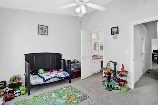 carpeted bedroom with ensuite bathroom, ceiling fan, and vaulted ceiling