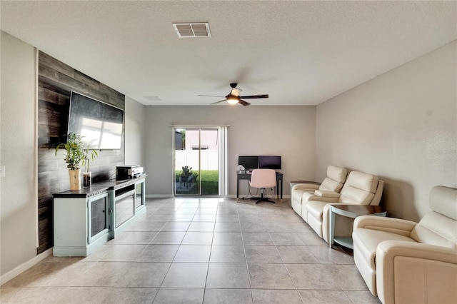 tiled living room with ceiling fan and a textured ceiling