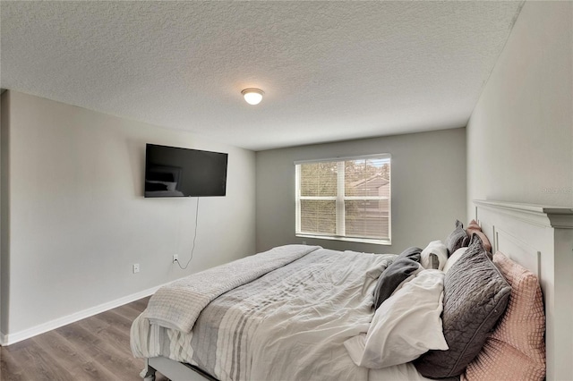 bedroom with a textured ceiling and hardwood / wood-style floors