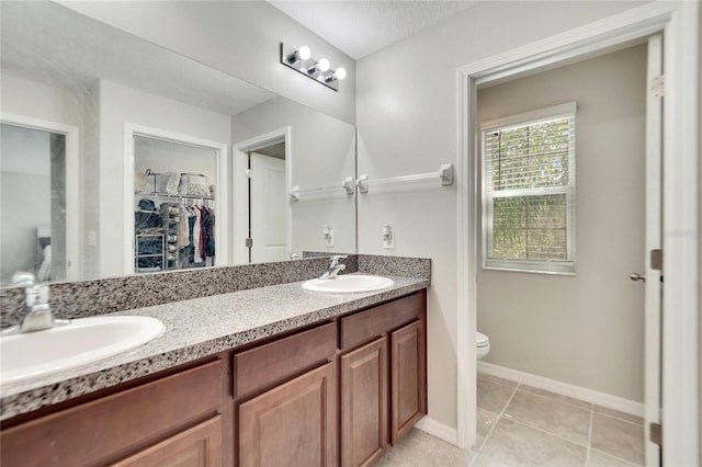 bathroom with tile patterned flooring, vanity, and toilet