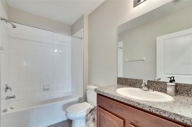 full bathroom featuring a textured ceiling, tiled shower / bath, vanity, and toilet