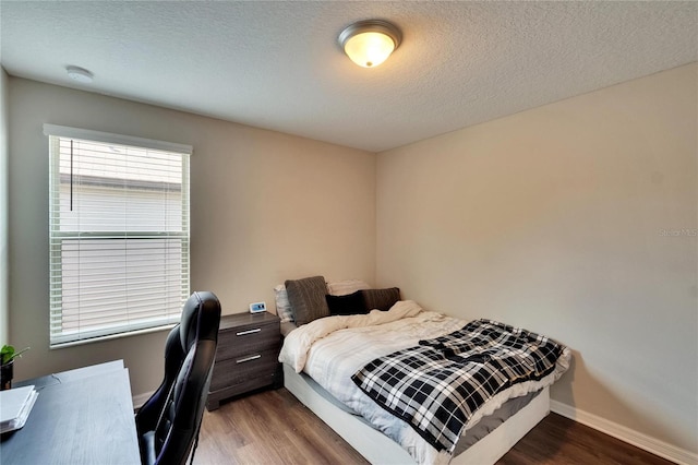 bedroom with a textured ceiling and hardwood / wood-style floors