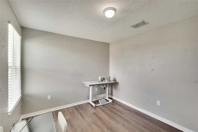 laundry area featuring a textured ceiling and light hardwood / wood-style floors