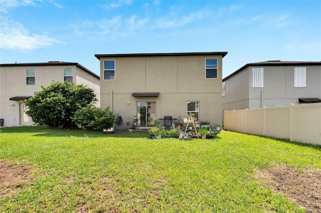 back of house with a lawn