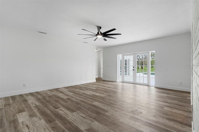 spare room featuring baseboards, a ceiling fan, wood finished floors, and visible vents