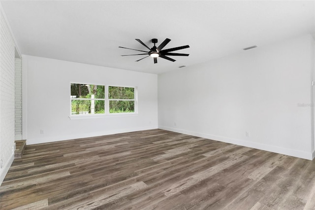 empty room with ceiling fan and dark wood-type flooring