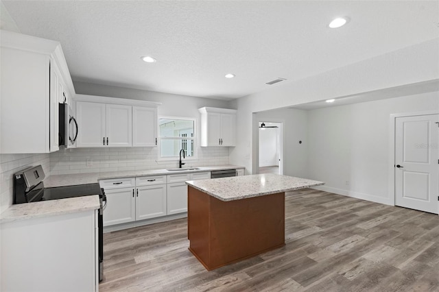 kitchen featuring white cabinetry, a center island, light hardwood / wood-style flooring, and stainless steel appliances