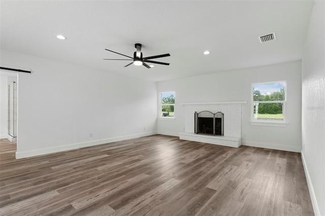 unfurnished living room featuring a fireplace, plenty of natural light, and hardwood / wood-style floors