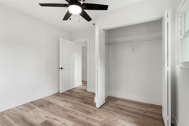 unfurnished bedroom featuring light wood-type flooring, ceiling fan, and a closet