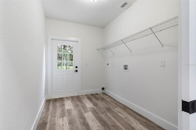 laundry room featuring laundry area, visible vents, wood finished floors, baseboards, and hookup for a washing machine