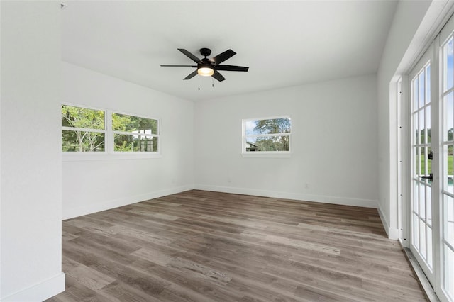 unfurnished room featuring light wood-type flooring, a healthy amount of sunlight, and ceiling fan