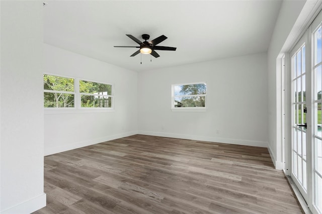 spare room featuring baseboards, a ceiling fan, and a healthy amount of sunlight
