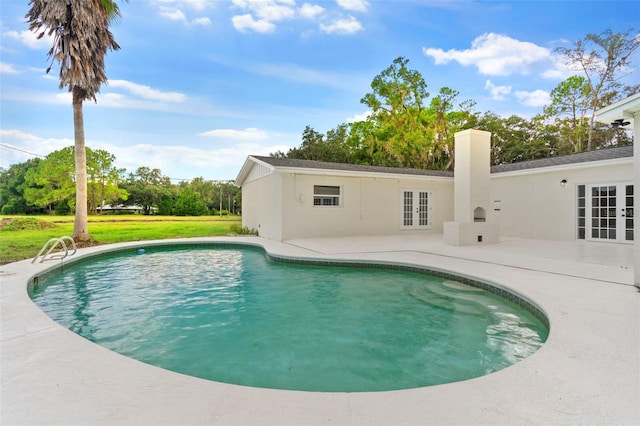 view of pool featuring a patio, a lawn, and french doors