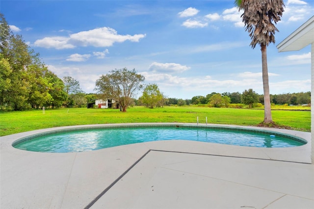 pool with a lawn and a patio area