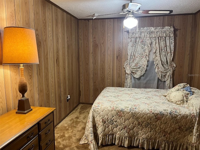 carpeted bedroom featuring wood walls, a textured ceiling, and ceiling fan